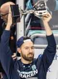 Man in a blue Seattle Kraken shirt and cap holding a trophy.