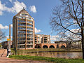 View of a pencil shaped apartment building adjacent to canal Espelervaart