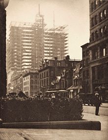 A sepia view of 19th-century Italianate mansions being dwarfed by a steel-girder structure, the core of the future Vanderbilt Hotel