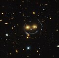 "Smiley" – ammasso (SDSS J1038+4849) e lente gravitazionale (un anello di Einstein) (HST).[16]