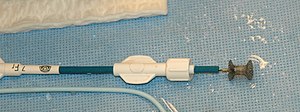 A nitinol device for closing muscular VSDs, 4 mm diameter in the centre. It is shown mounted on the catheter into which it will be withdrawn during insertion. VSD plug.jpg