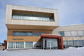 Foto eines Gebäudes mit Holzfassade, das abgebildete Gebäude wirkt modern