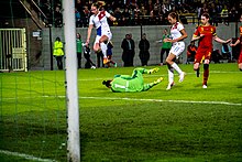 Woman jumping over another woman who is down on the grass