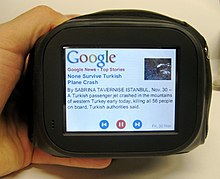 A Chumby being held and displaying a Google News story Chumby in hand.jpg