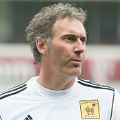 A dark-haired man wearing a white shirt.