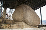 A large rock under a modern roof