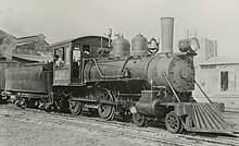 A black-and-white image of an old steam locomotive and tender