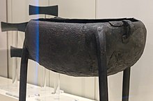 Colour photograph of a three-legged metal vessel