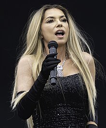 A headshot of singer Shania Twain, against a white background.