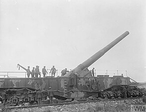 Photographie montrant le roi George V inspecte le H.M. Gun « Boche Buster », canon naval de 14 pouces monté sur chemin de fer, à Marœuil, à 10 km au nord-ouest d’Arras, en France, le 8 août 1918