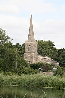 A stone church seen from the southeast, showing chancel, beyond which is a taller nave with a south aisle, and a tower with a spire