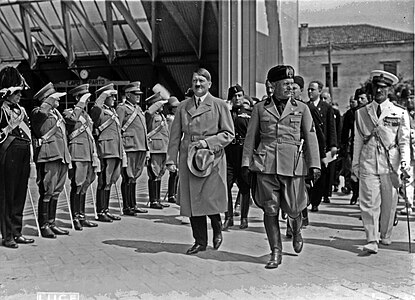 İtalya'ya yaptığı ilk ziyaretinde İtalyan generaller tarafından selamlanan Adolf Hitler, solunda Benito Mussolini (Venedik Havalimanı, 14 Haziran 1934) (Üreten: Istituto Nazionale Luce (Library of Congress); yükleyen: Madmax32)