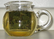 A small clear pot with green oolong tea