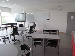 Aula con diferentes formatos de mesas y equipos audiovisuales