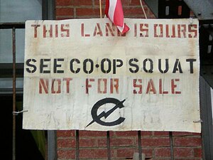 Sign that says "THIS LAND IS OURS. SEE CO-OP SQUAT. NOT FOR SALE."