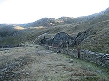 The quarry in 2007, showing the remains of the fan house by the main adit and the site of the mill. Croesor.jpg