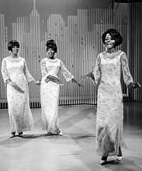 The Supremes scored four #1 hits in 1965 with "Come See About Me", "Stop! In the Name of Love", "Back in My Arms Again" and "I Hear a Symphony". The Supremes 1966.JPG