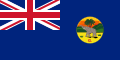 This is the SVG vector image of the flag and government ensign of the Colony of The Gambia from 1889 to 1965. It is recommended to create a new SVG vector image based on this SVG. Just change the background color from blue to the same red as the Union Flag in the upper left corner. In addition, the black edge around the round badge should be removed.