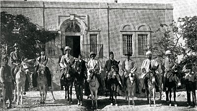 Photo en noir et blanc des membres de la mission montés sur des ânes.