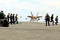 Flight deck personnel prepare for the next launch after an F/A-18C leaves the flight deck