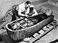 Howard Carter egiptologoa Tutankhamonen sarkofagoa eta momiaren aurrean.