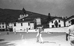 Vue en noir et blanc de joueurs de rebot, avec l’église en arrière plan.