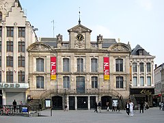 Photo du Théâtre du Nord, de part et d'autre du bâtiment se trouve un escalier permettant d’accéder au premier étage. Une horloge surplombe le bâtiment au centre.