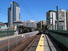 The platforms of an elevated light rail station in an urban area