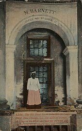 Caption of a 20th-century picture postcard: "The Old Slave Block in the Old St. Louis Hotel, New Orleans, La. The colored woman standing on the block was sold for $1500.00 on this same block when a little girl."