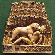 Plaque montrant un lion mordant le cou d'un homme sur le dos, une des ivoires de Nimrud (en), période Néo-Assyrienne, IXe – VIIe siècle av. J.-C.