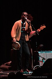 Harding singing on stage with a tambourine at his thigh