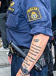 En polis med armtatueringar.