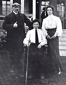 Three golfers, one man and two women, posed outdoors.