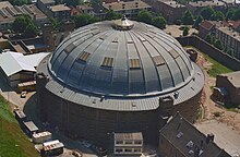 A large grey dome from bird's eye view in an urban setting