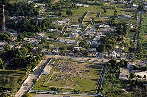 Makeshift tents are set up at a soccer field, one of the few areas free from debris