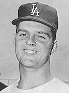 A baseball player in a Dodgers uniform, smiling at the camera