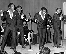 Four Tops onstage in suits, dancing