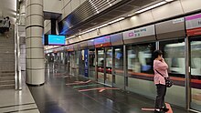 The station platform is separated from an incoming train by the platform screen doors.