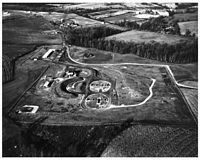 This Nike Ajax site has only two launch areas, the oval-shaped areas in the middle of the image. The rectangular openings are elevators that raise the missiles from their underground storage areas, and the four launchers are the small squares on either side. To the left of the launchers is the refueling area, surrounded by a high berm in case one of the missiles exploded.