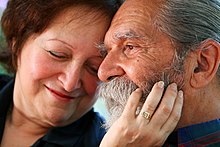 A woman touches a man's face.