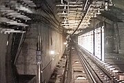 The installation of screen doors has started at the reserved platform structure in the eastbound tunnel of Line 6, and the previously installed site lighting strips are still visible (June 2022)