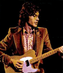 Robbie Robertson playing a guitar