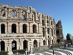 A picture of a large stone building, with several framed openings meant to resemble windows.