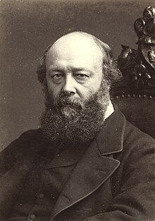 A serious-looking middle-aged man, with bags under his eyes and a full beard, in nineteenth-century formal dress