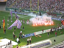Players run by flares on the field