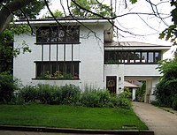 A two-story house surrounded by trees