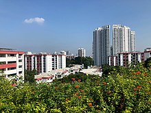 Apartment blocks of varying heights behind a field