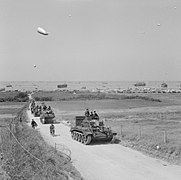 Column of British vehicles moving inland from King Sector, Gold Beach, on 7 June 1944