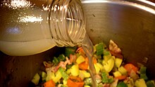 Bottled clam juice being used in preparation of clam chowder