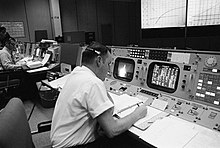 Clifford Charlesworth assis à sa console (vu ici de dos durant le vol Apollo 8).